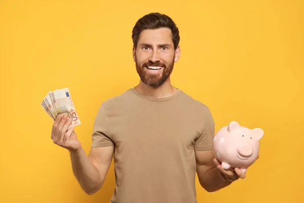 Happy Man Money Ceramic Piggy Bank Orange Background — Stock Photo, Image