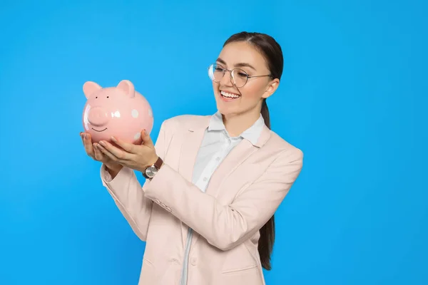 Jovem Empresária Feliz Com Banco Porquinho Fundo Azul Claro — Fotografia de Stock