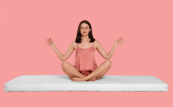 Giovane Donna Meditando Sul Materasso Morbido Contro Sfondo Rosa Pallido — Foto Stock