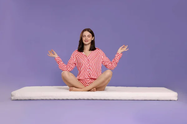 Mujer Joven Meditando Sobre Colchón Suave Sobre Fondo Púrpura Claro —  Fotos de Stock