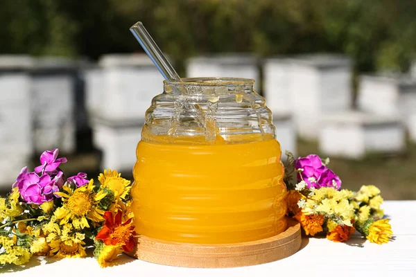 Läcker Färsk Honung Och Vackra Blommor Vitt Träbord Bikupa — Stockfoto