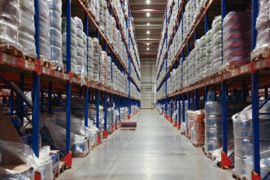 Depo içi, içi mal dolu metal raflarla dolu. Toptan satış işi.