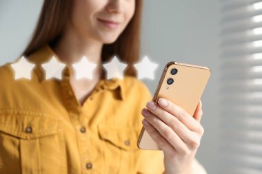Akıllı telefonu olan bir kadın içeride geri bildirim yapıyor, yakın plan. Müşteri değerlendirmesi