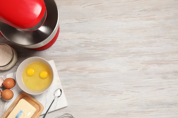 stock image Modern red stand mixer and different ingredients on white wooden table, flat lay. Space for text