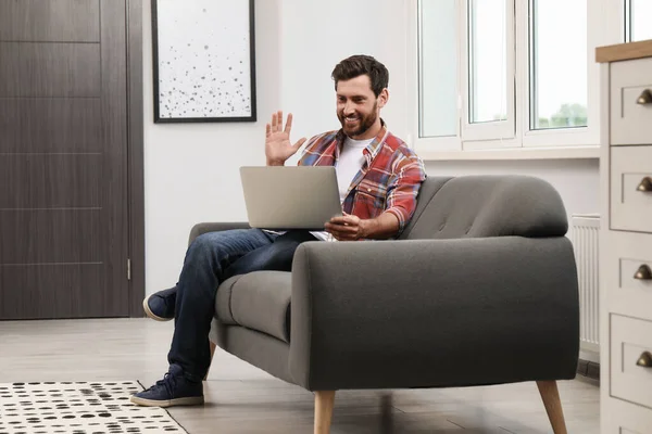 stock image Happy bearded man having video chat on laptop at home