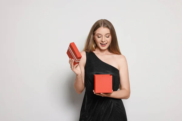 Emocionální Mladá Žena Elegantní Černé Šaty Otevření Červené Dárkové Krabice — Stock fotografie