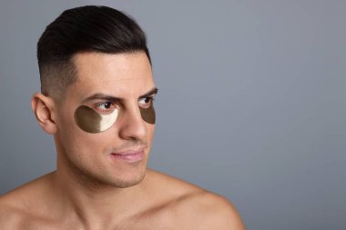 Gri arka planda koyu renk göz bandı olan bir adam. Metin için boşluk