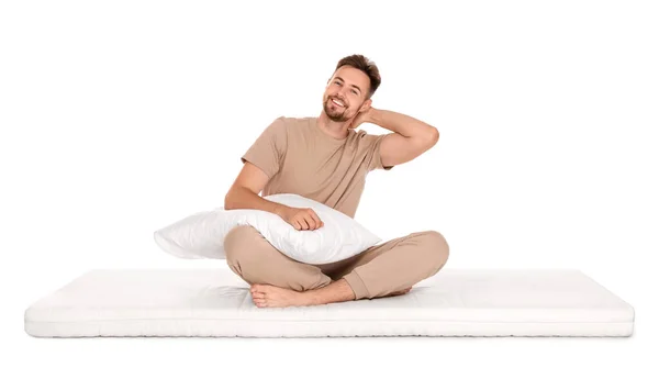 Lächelnder Mann Mit Kopfkissen Sitzt Auf Weicher Matratze Vor Weißem — Stockfoto