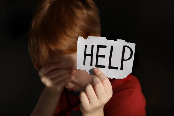 Kleiner Junge Hält Zettel Mit Dem Wort Hilfe Vor Schwarzem — Stockfoto