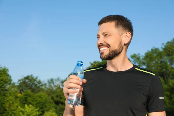 stock image Happy man with bottle of water on hot summer day. Refreshing drink