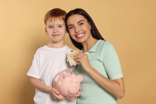 Moeder Haar Zoon Met Keramische Piggy Bank Beige Achtergrond — Stockfoto