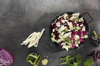 Çin lahanalı leziz salata, suluguni peyniri ve gri masada dolgun biber. Metin için boşluk