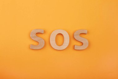 Kısaltma SOS turuncu arka planda ahşap harflerden yapılmıştır, üst görünüm