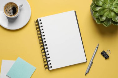 Düz kompozisyon ve sarı arka planda şık bir defter.
