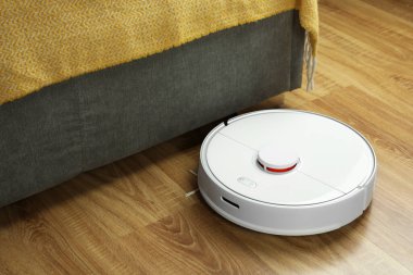 Robotik süpürge, ahşap zeminde, kapalı alanda.