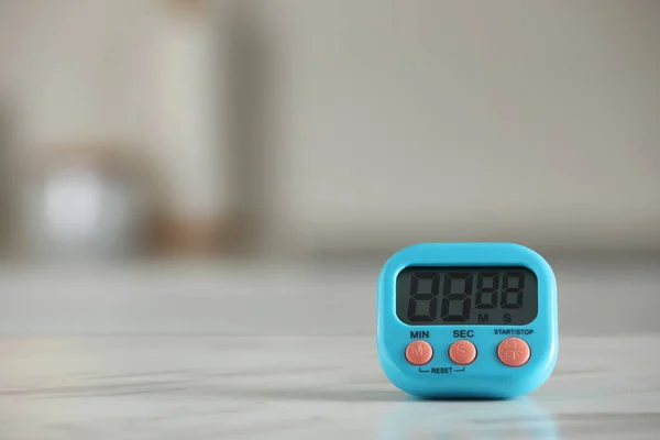 stock image Kitchen timer on white marble table against blurred background. Space for text