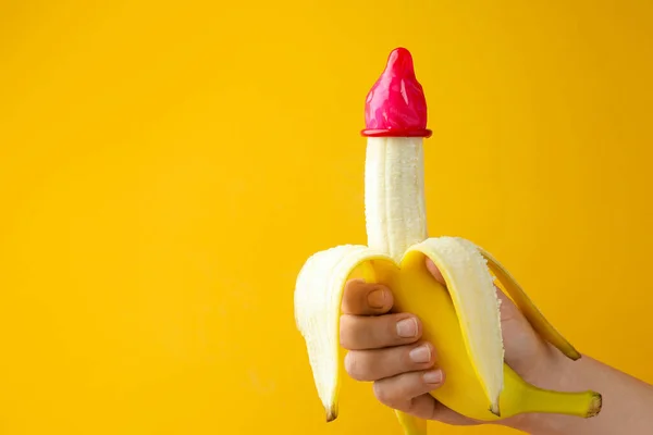 Γυναίκα Κρατώντας Μπανάνα Προφυλακτικό Πορτοκαλί Φόντο Closeup Και Χώρο Για — Φωτογραφία Αρχείου