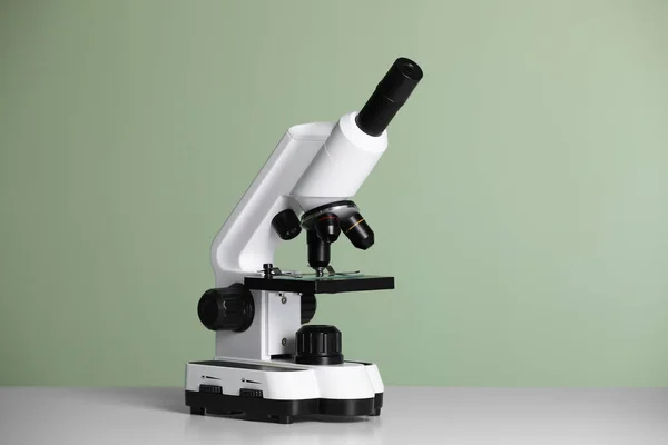Modernt Mikroskop Bordet Mot Grön Bakgrund — Stockfoto