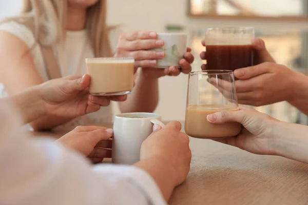 stock image Friends drinking coffee at wooden table in cafe, closeup