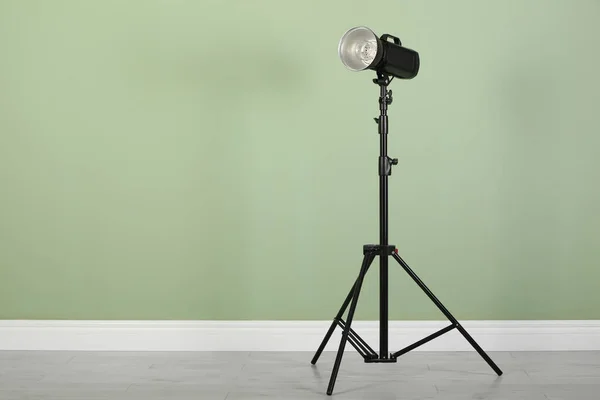 工作室闪光灯 三脚架上有反射镜 房间里靠近浅绿色墙壁 有文字空间 专业摄影师设备 — 图库照片