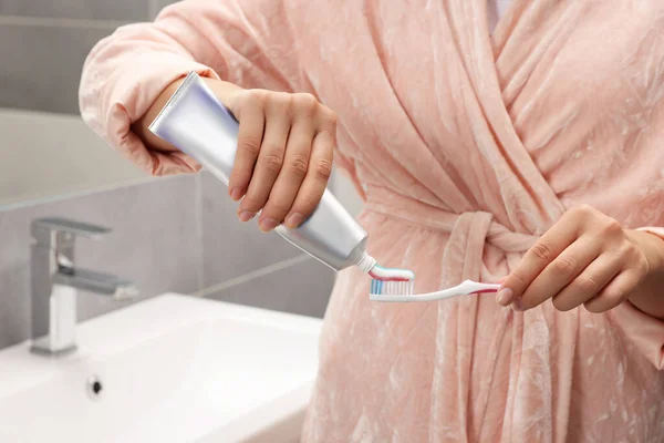 Mulher Aplicando Pasta Dentes Escova Banheiro Close — Fotografia de Stock