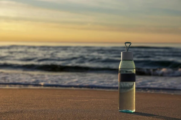 Botella Vidrio Con Agua Sobre Arena Mojada Cerca Del Mar —  Fotos de Stock