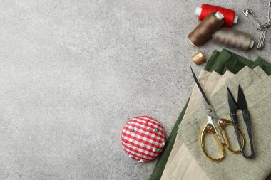 Işık desenli tablo üzerinde iplik makaraları ve dikiş araçları ile düz bileşim, metin için boşluk