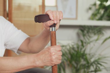 Elderly woman with walking cane indoors, closeup. Home care service
