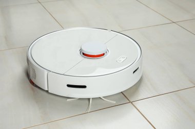 Beyaz döşemede robotik süpürge.