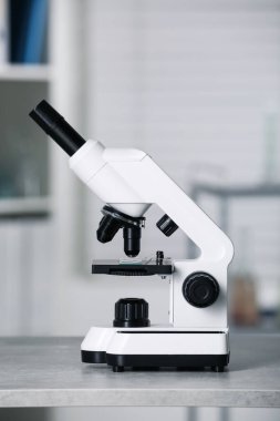 Modern medical microscope on grey table in laboratory