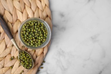 Cam kavanoz mung fasulyesi, beyaz mermer masa üzerinde kaşık, üst manzara. Metin için boşluk