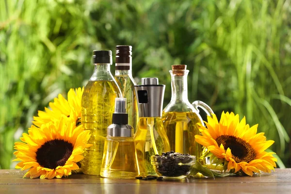 Veel Verschillende Flessen Met Bakolie Zonnebloempitten Bloemen Houten Tafel Tegen — Stockfoto