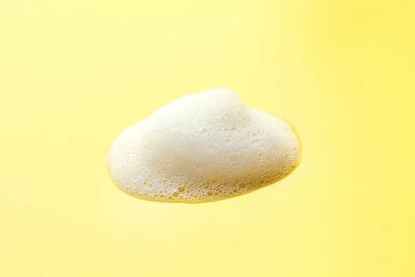 stock image Drop of fluffy soap foam on yellow background