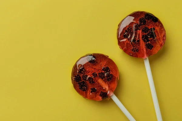 stock image Sweet colorful lollipops with berries on yellow background, flat lay. Space for text