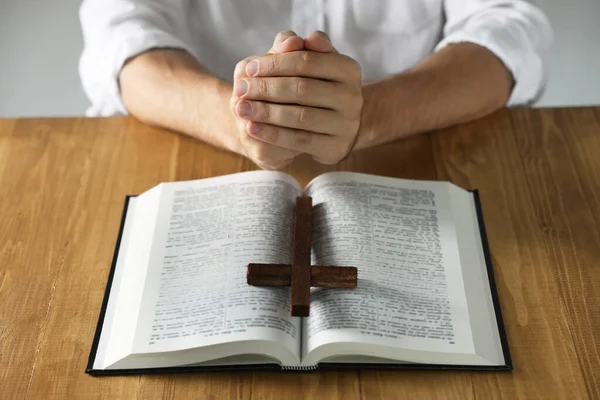 Człowiek Biblią Krzyżem Modlący Się Przy Drewnianym Stole Zbliżenie — Zdjęcie stockowe