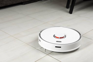 Beyaz fayanslı zeminde robotik süpürge, metin için boşluk