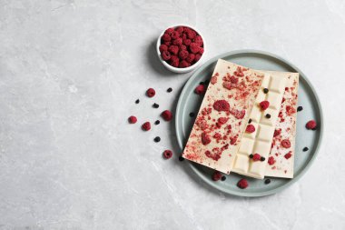 Gri mermer masada dondurulmuş meyveleri olan beyaz çikolatalar. Metin için boşluk