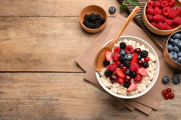 stock image Flat lay composition with tasty oatmeal porridge and ingredients served on wooden table. Space for text