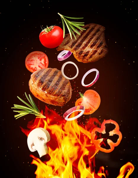 濃い背景の上でおいしい焼き肉 異なる野菜や火の炎 — ストック写真