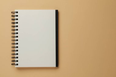 Blank notebook on beige background, top view. Space for text