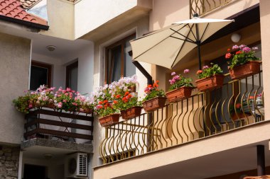 Balkonları ve çiçekleri olan güzel bir apartmanın dış cephesi.