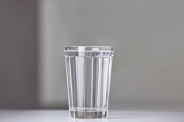 Glass of pure water on white table indoors, space for text