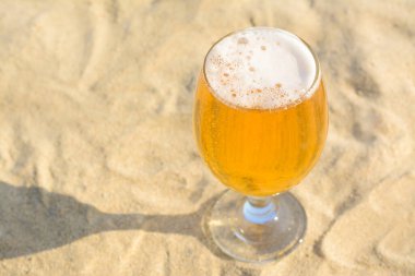 Kumsalda bir bardak soğuk bira, yakın plan. Metin için boşluk