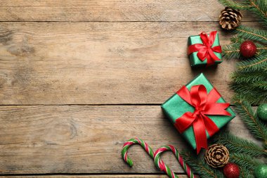 Hediye kutuları, şeker kamışı, köknar ağacı dalları ve ahşap masa üzerindeki Noel süsü, düz yatış. Metin için boşluk