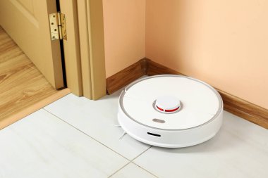 Beyaz zeminde modern robotik elektrikli süpürge.