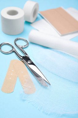 White bandage and medical supplies on light blue background, closeup clipart