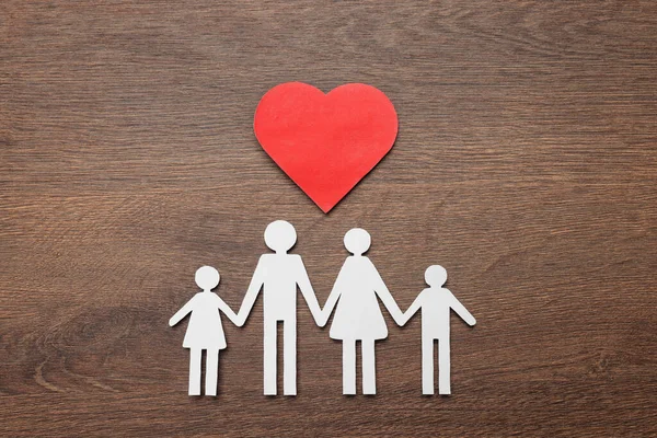 Paper family cutout and red heart on wooden background, flat lay. Insurance concept