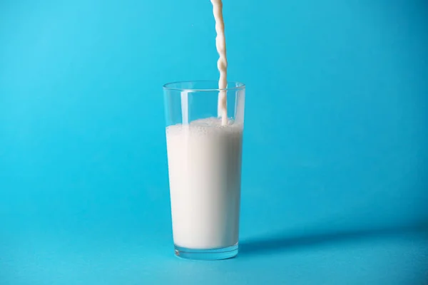 Açık Mavi Arkaplanda Bardağa Taze Süt Dökülüyor — Stok fotoğraf