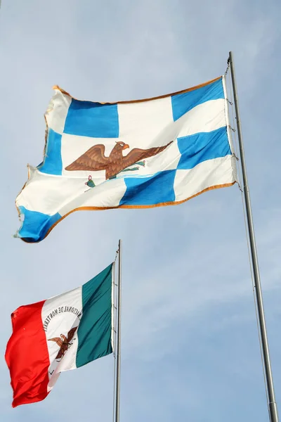 Mexico flags fluttering against blue sky on sunny day, low angle view
