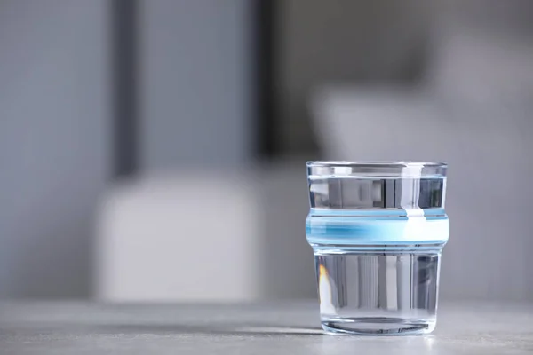 Gelas Air Bersih Pada Meja Abu Abu Terang Dalam Ruangan — Stok Foto